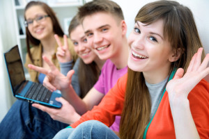 Close-up of four teenagers laughing and gesturing at camera